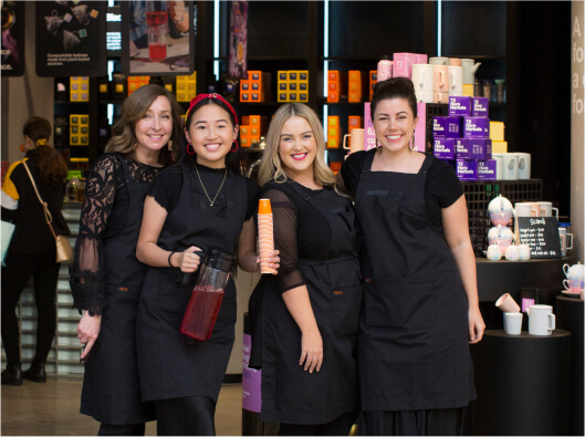 Four T2 store employees smiling together side by side