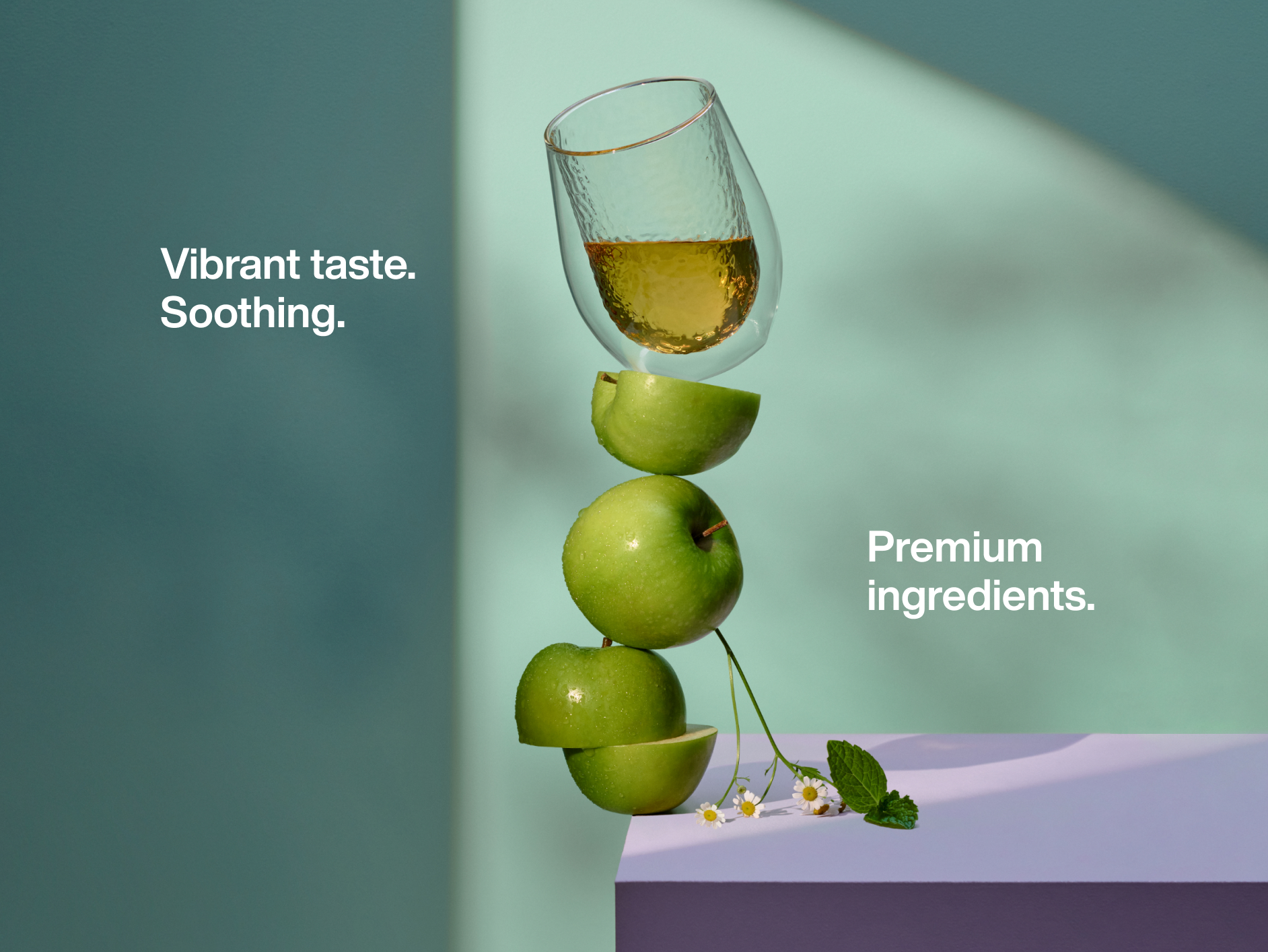 Stack of apples balancing with a cup of tea on top