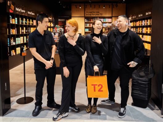 Four T2 store employees smiling together side by side