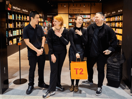 Four T2 store employees smiling together side by side