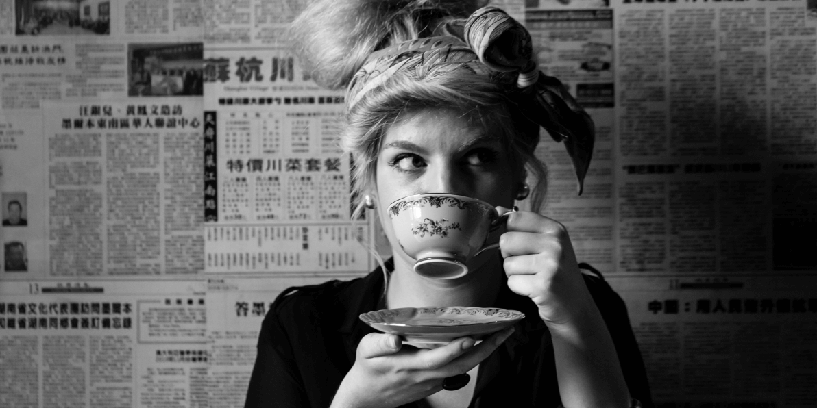 Portrait of a lady in a head scarf drinking tea