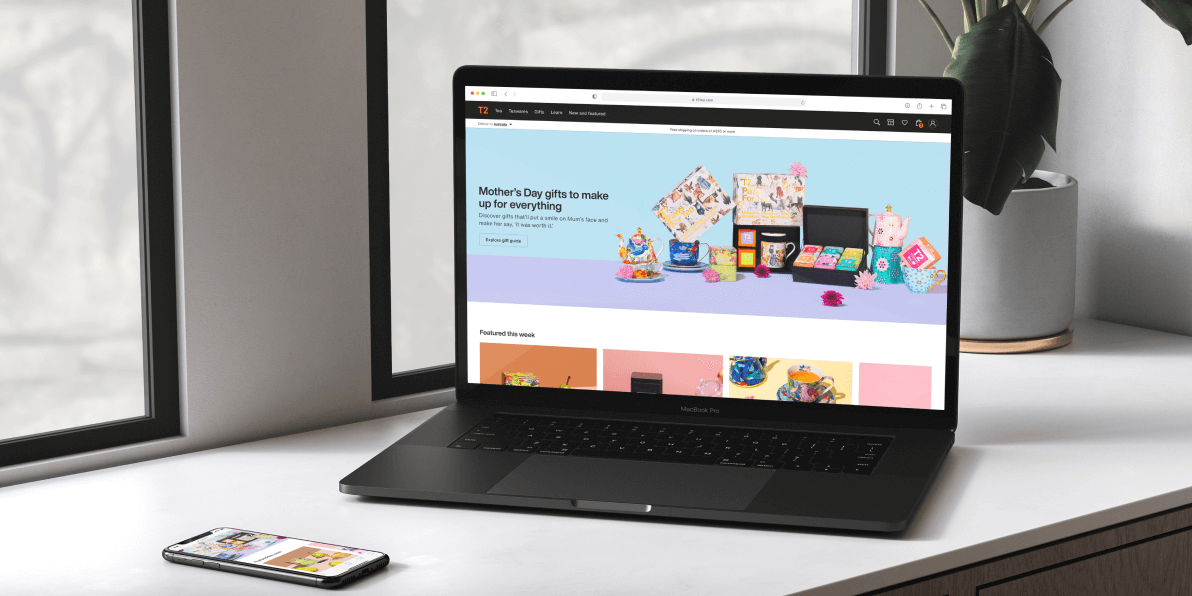 Laptop on a desk showing the T2 website