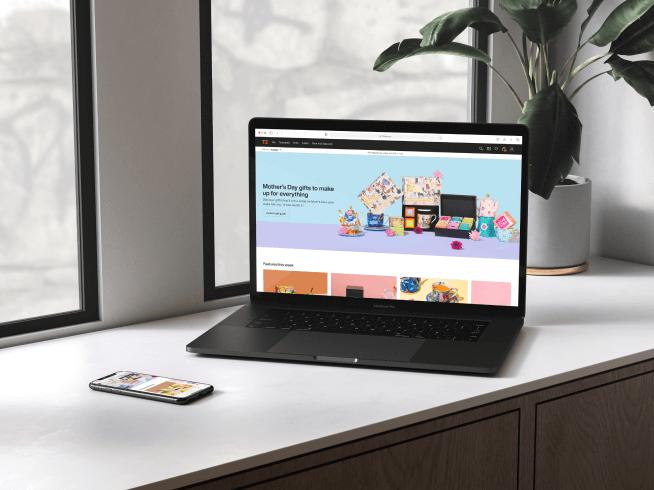 Laptop on a desk showing the T2 website