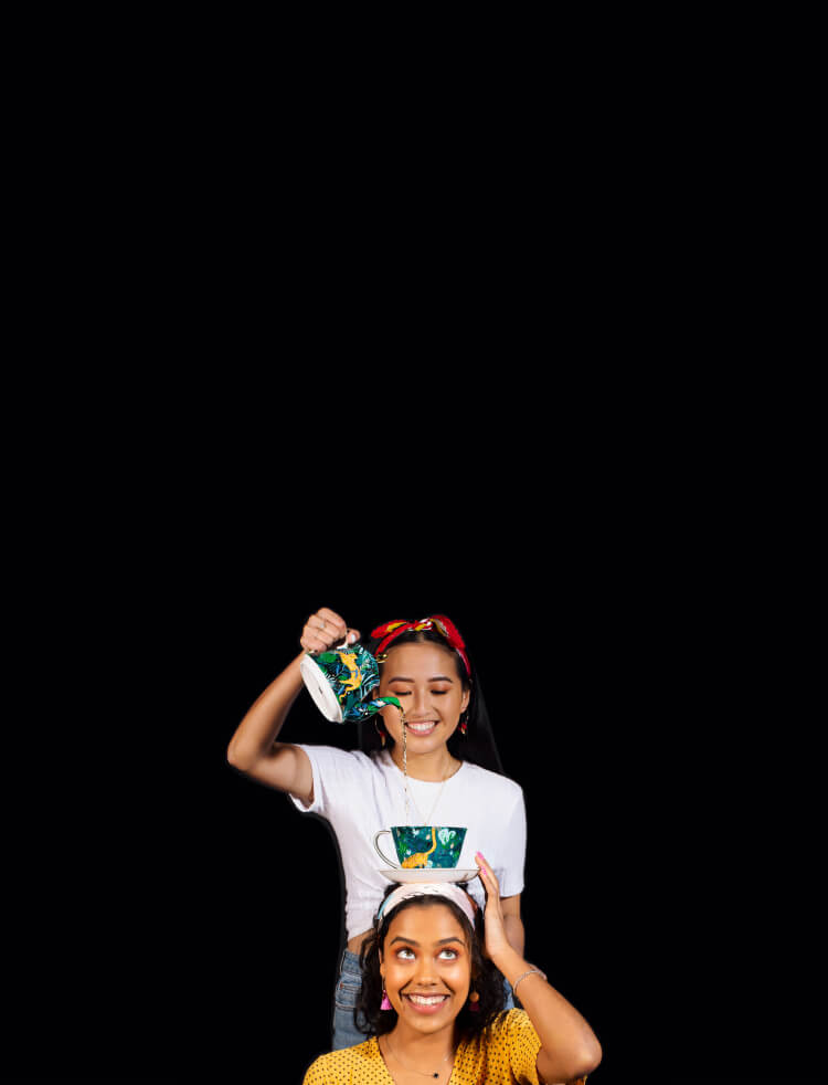 Two friends smiling and having fun with tea.