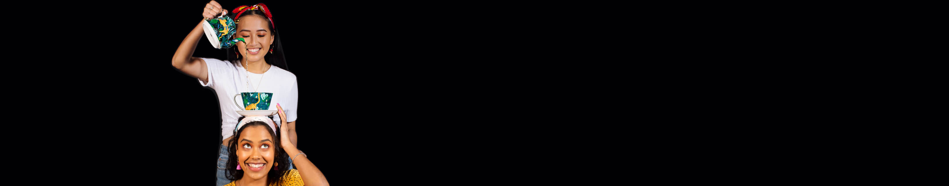 Two friends smiling and having fun with tea.