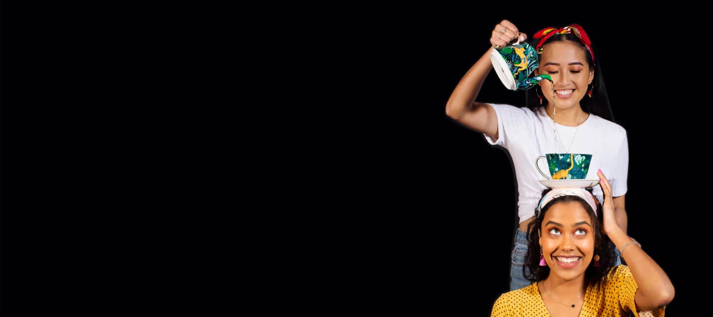 Two friends smiling and having fun with tea.
