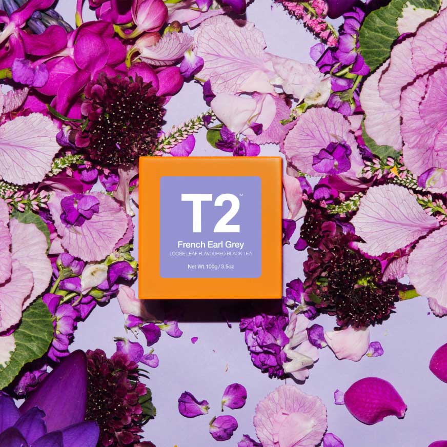A box of french earl grey surrounded in flower petals