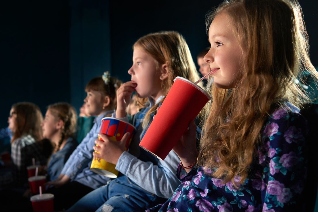 Young girls watching a movie screen in the cinema